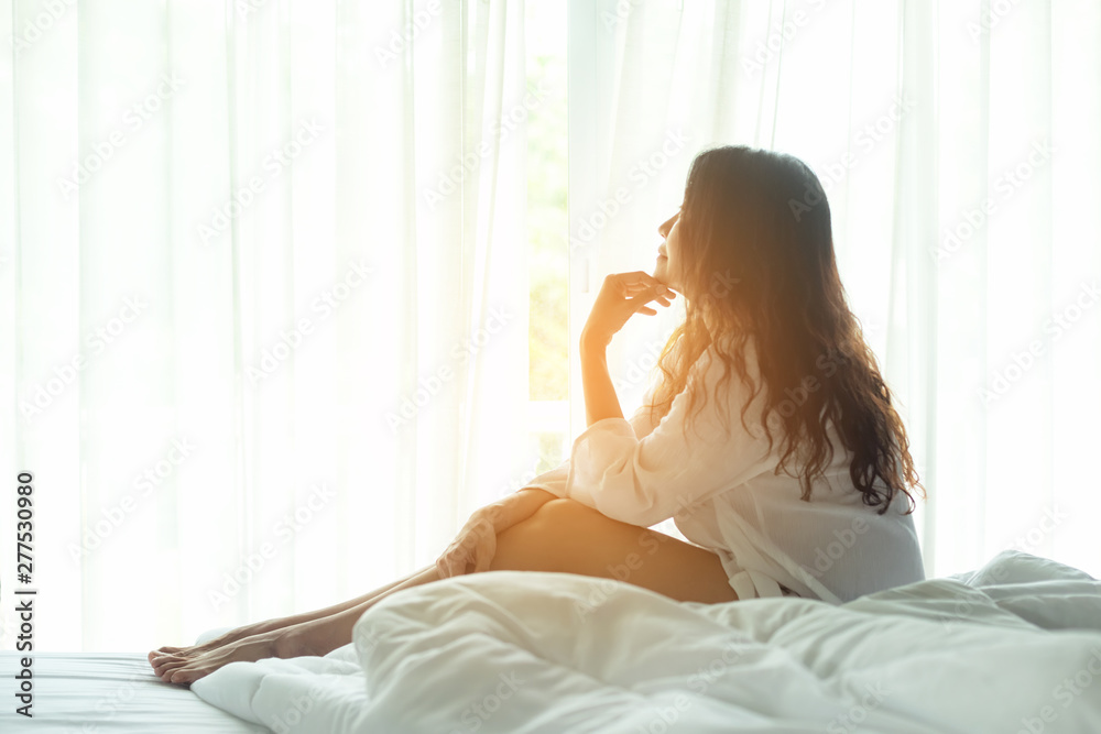 Asian woman in bedroom relax after wake up near window, sunny morning. Lifestyle Concept. Asian woman in bedroom relax after wake up near window, sunny morning. Lifestyle Concept.
