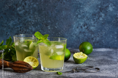 Summer cold drink - mahito with lime and mint on a concrete dark background.