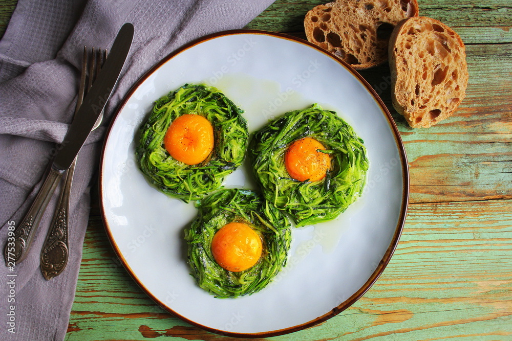 Fried egg in zucchini noodle nest, healthy breakfast, top view Fried egg in zucchini noodle nest, healthy breakfast, top view