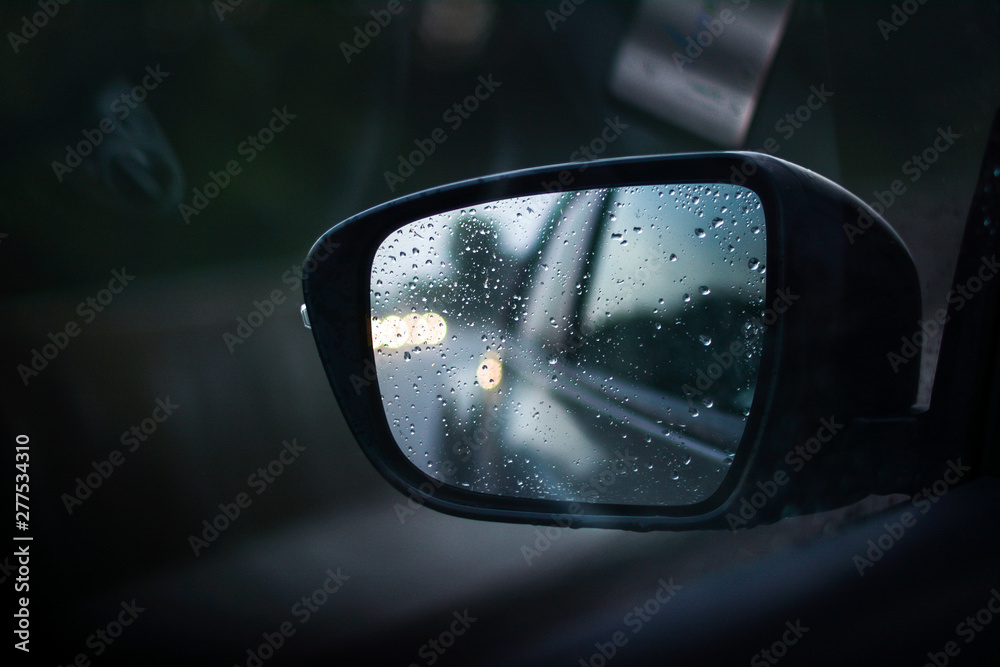 Drops on the car mirror after driving in the rain Drops on the car mirror after driving in the rain