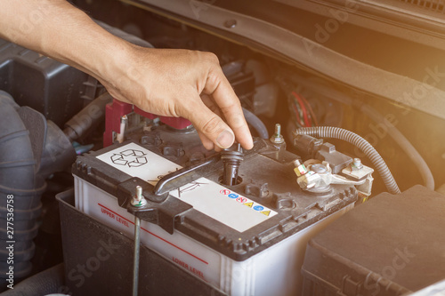 Auto mechanic working check system water and battery fill an old car engine at service station,change and repair before drive