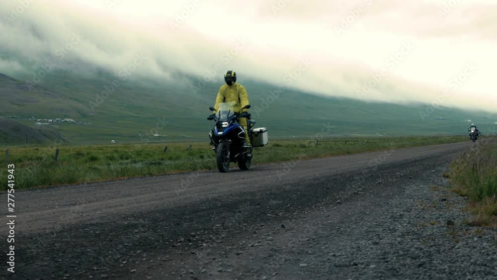 Two men driving their motorbikes. The one with yellow jacket is on the front. Two men driving their motorbikes. The one with yellow jacket is on the front.