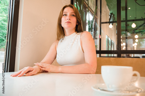 Girl is waiting for a meeting in cafe