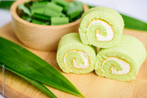 Pandan roll cake and fresh pandan leaf on wooden photo