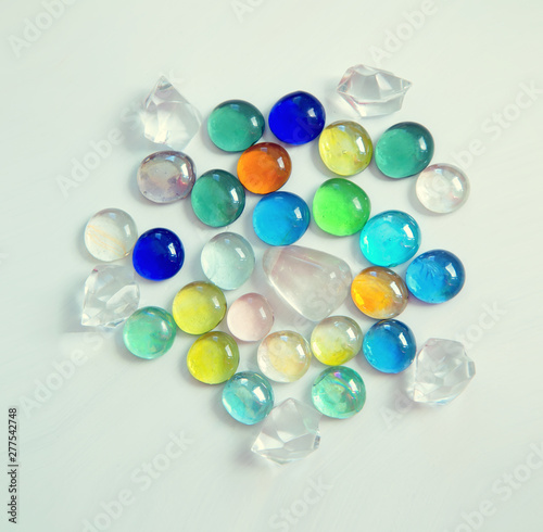 Multicolored glass round crystals on a light background.
