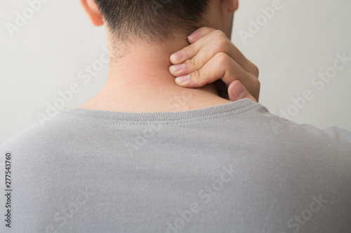 Photograph of a man from the back with pain and neck injury