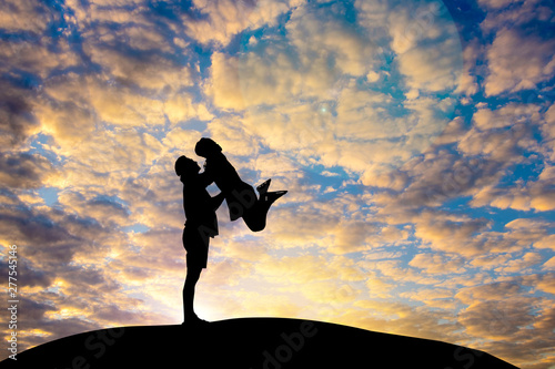 Man and woman in love. Man standing and  lift woman They are see the sun set.love, relationship.Photo concept Silhouette and love.