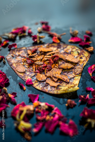 Close up of Famous Indian traditional masala pan or meetha pan on black surface with some rose water consisting of coated sauf,supari,sweeteners and some coconut powder. photo