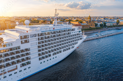Obraz na płótnie Cruise liner moored at the embankment in the waters of the river in the evening at sunset