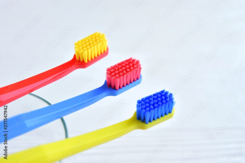 Colorful toothbrushes with selective focus on blurred neutral background. Dental tools for daily teeth protection. Multicolored plastic toothbrush with bright bristles with soft focus. Oral hygiene Colorful toothbrushes with selective focus on blurred neutral background. Dental tools for daily teeth protection. Multicolored plastic toothbrush with bright bristles with soft focus. Oral hygiene
