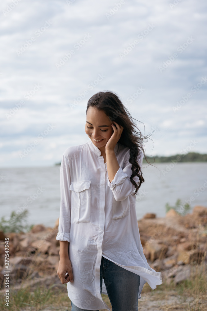 Authentic portrait of happy Korean girl walking, enjoying sea landscapes, breathing fresh air. Cheerful asian woman with emotional face and beautiful smile standing near river. Positive lifestyle Authentic portrait of happy Korean girl walking, enjoying sea landscapes, breathing fresh air. Cheerful asian woman with emotional face and beautiful smile standing near river. Positive lifestyle