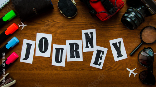 Word journey letters inscription wooden table top view. Preparation for the vacation travel concept