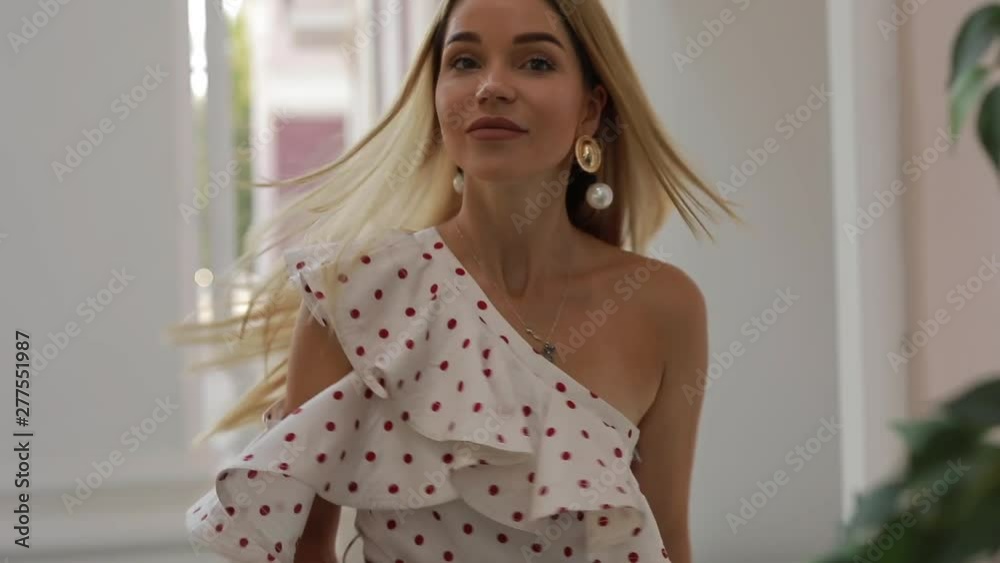 Beautiful pretty elegant woman in dress looking back at me near building columns