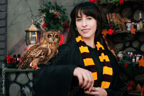 Sorceress with an owl. Beautiful girl with long hair conjures. Young witch with a magic wand photo