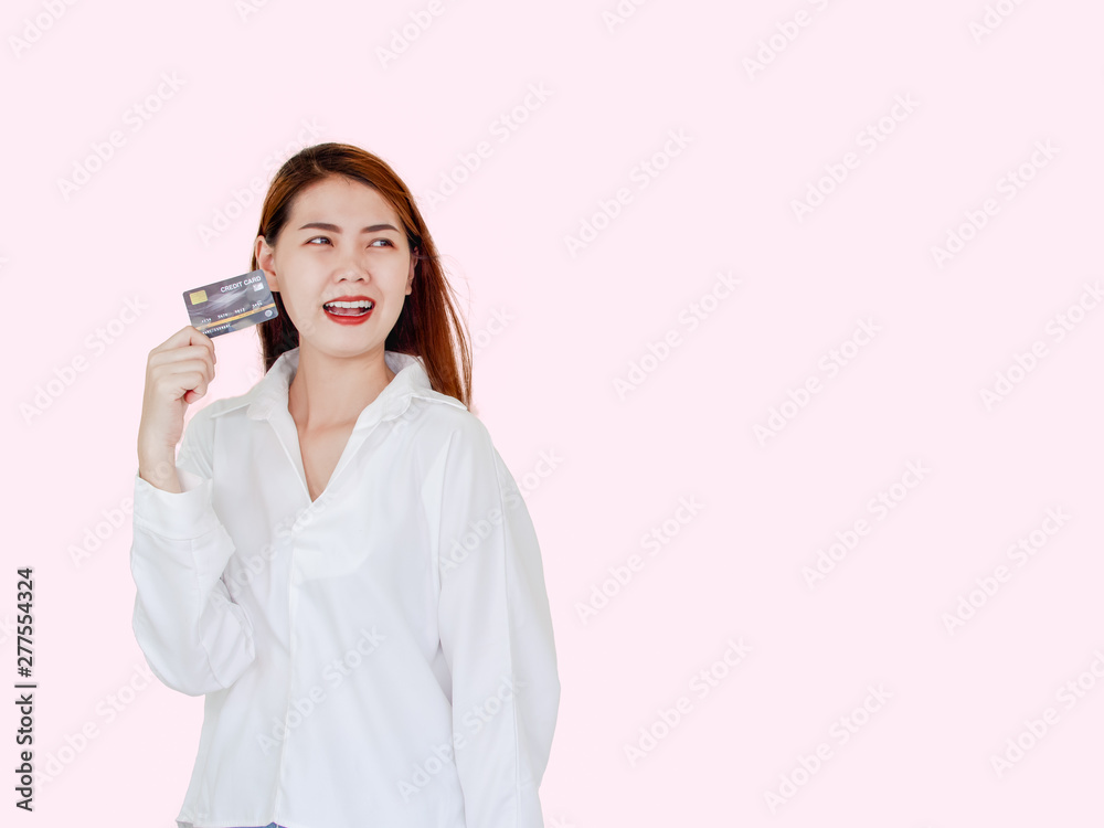 Happy young asian woman holding credit card in hand, showing confidence for making payment with feeling excited and amazed, isolated on pink background. Happy young asian woman holding credit card in hand, showing confidence for making payment with feeling excited and amazed, isolated on pink background.