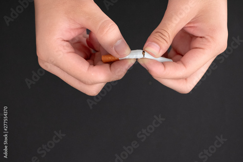 Quit smoking hand hold cigarette destroy isolated on black background.