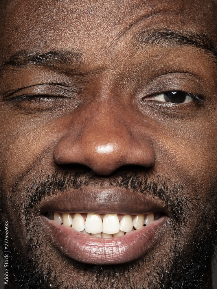 Close up portrait of young and emotional african-american man. Highly detail photoshot of male model with well-kept skin and bright facial expression. Concept of human emotions. Happy smiling, playful Close up portrait of young and emotional african-american man. Highly detail photoshot of male model with well-kept skin and bright facial expression. Concept of human emotions. Happy smiling, playful