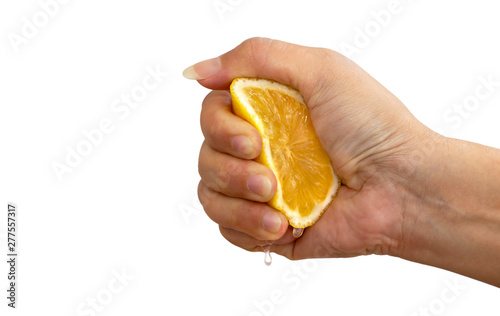 Women's hand squeezing a half of fresh lemon yellow on a white background.