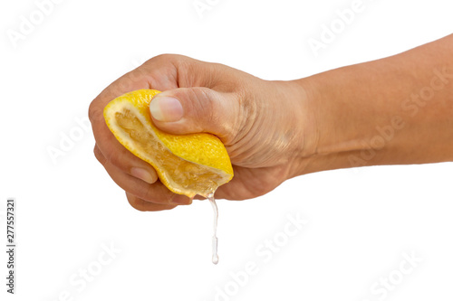 Women's hand squeezing a half of fresh lemon yellow on a white background.