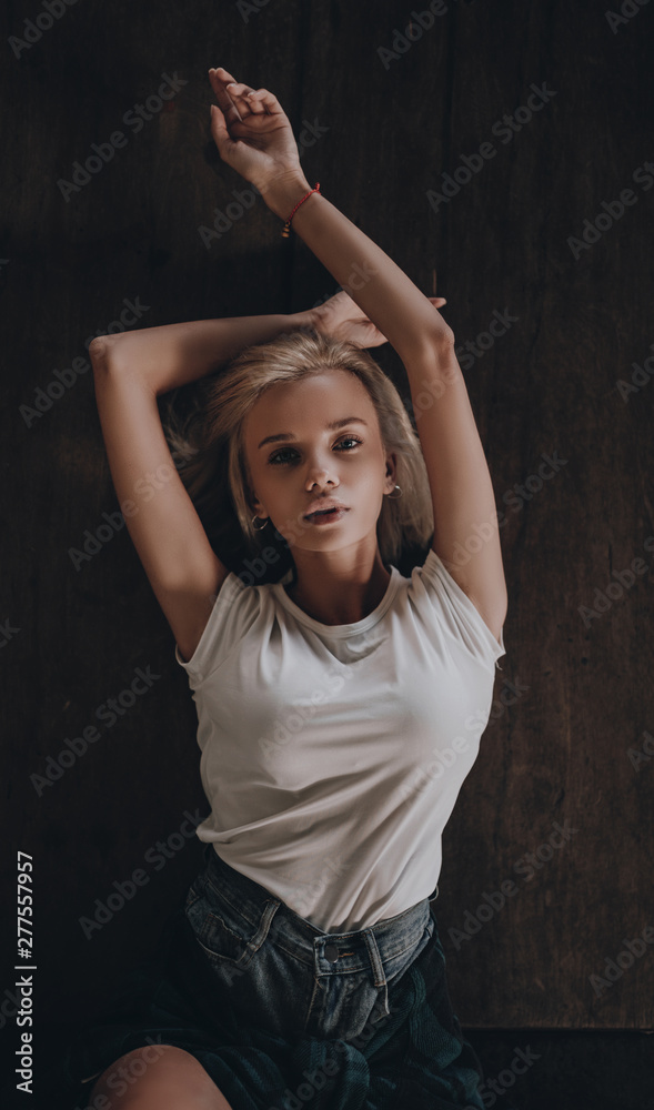 Seductive sexy stylish blonde girl posing on black background. Stylish urban trendy woman model on city street Seductive sexy stylish blonde girl posing on black background. Stylish urban trendy woman model on city street