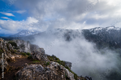 Montenegro, Misty atmosphere and extremely fast changing weather on summit of mount curevac at the edge of tara river canyon inside durmitor national park nature landscape near zabljak