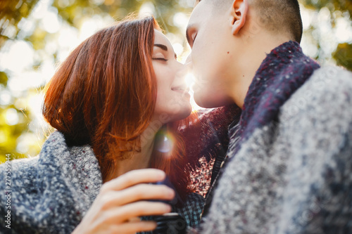 Cute couple in a park. Lady with red hair. Two people drinking a tea photo