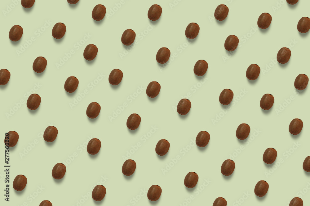 Summer brown kiwi pattern on the green pastel background. Tropical fruit wallpaper Summer brown kiwi pattern on the green pastel background. Tropical fruit wallpaper