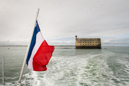 the flag of france with a sea fortress in the background