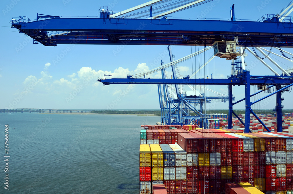 Fototapeta premium Gantry cranes are loading cargo on the container ship in port of Charleston, South Carolina. 