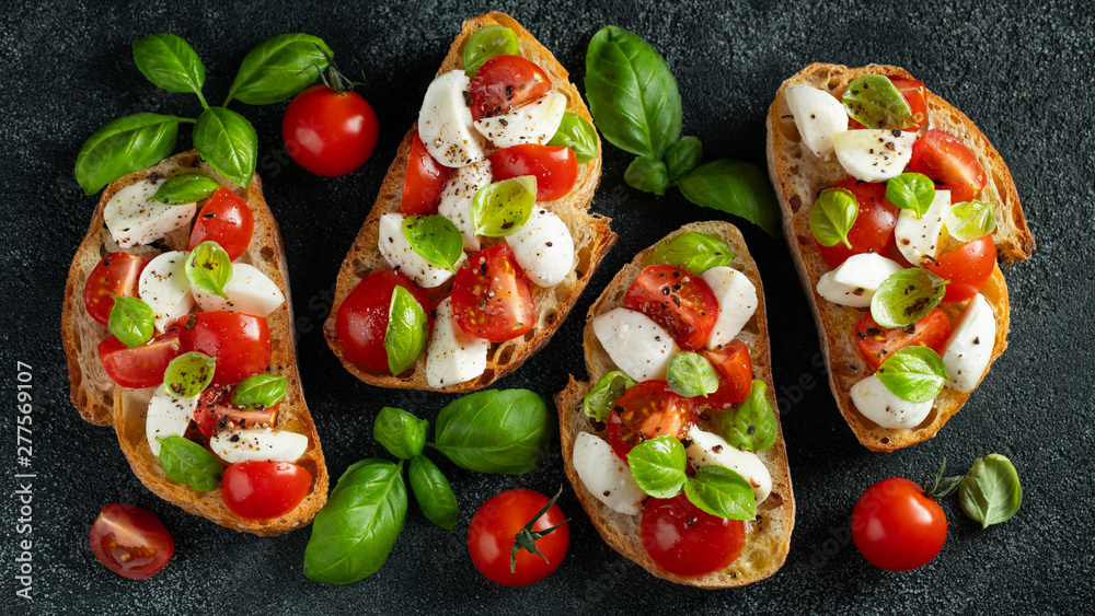 Bruschetta with tomatoes, mozzarella cheese and basil on a cutting board. Traditional italian appetizer or snack, antipasto. Top view with copy space. Flat lay Bruschetta with tomatoes, mozzarella cheese and basil on a cutting board. Traditional italian appetizer or snack, antipasto. Top view with copy space. Flat lay