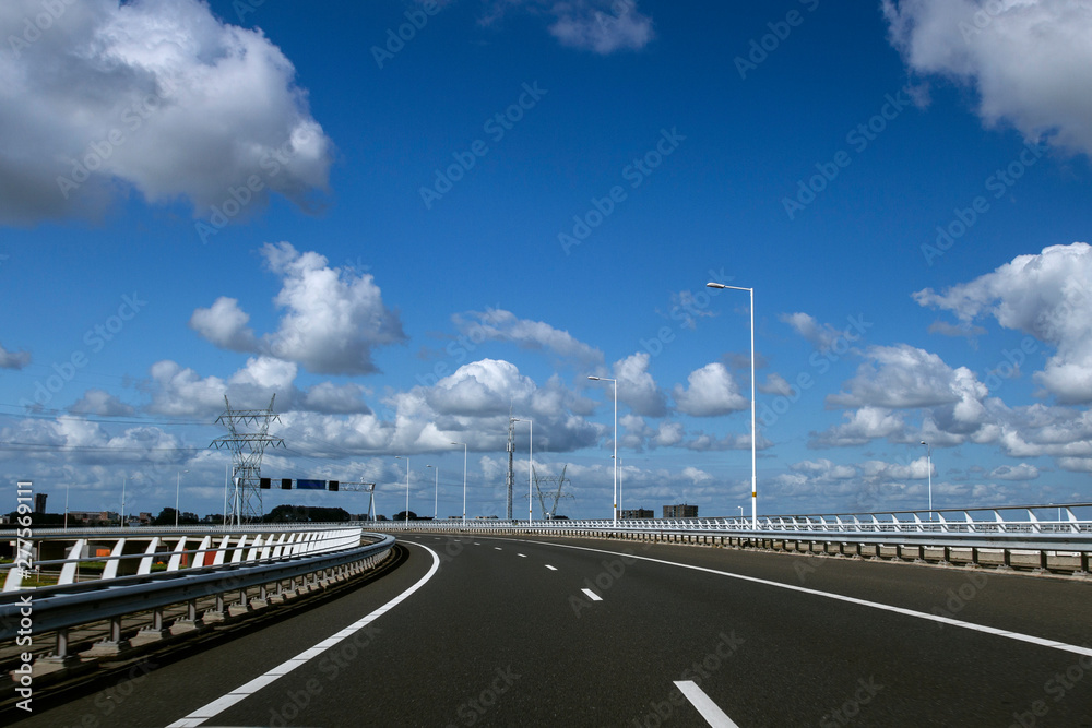 Empty  Freeway .  Long  asphalt road with white lines down the centre .  Travel and transportation concept. Travel .