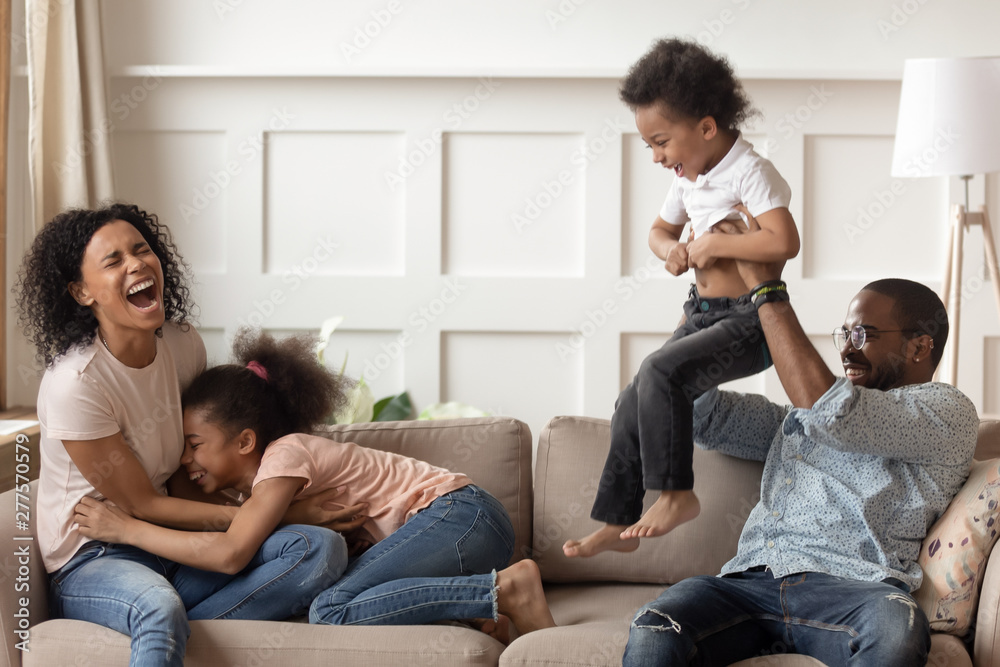 Happy black family having fun playing with children at home Happy black family having fun playing with children at home
