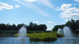 fountain in park with blue sky and clouds