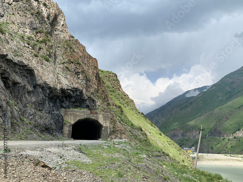 Russia, North Ossetia. Tunnel in Kassar gorge in summer in cloudy weather photo