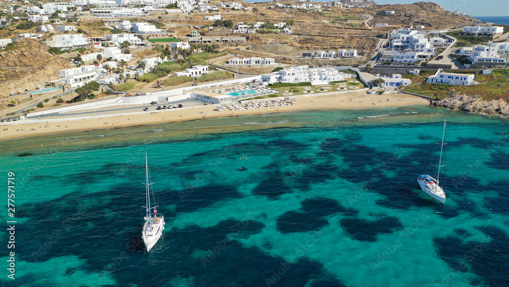 Aerial photo of famous sandy beach with turquoise clear sea of Megali Amos next to iconic and picturesque main town of Mykonos island, Cyclades, Greece