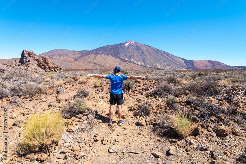 a tourist taking a photo with teide volcano at background