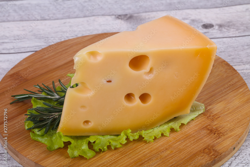 Maasdam cheese in the board served salad leaves Maasdam cheese in the board served salad leaves