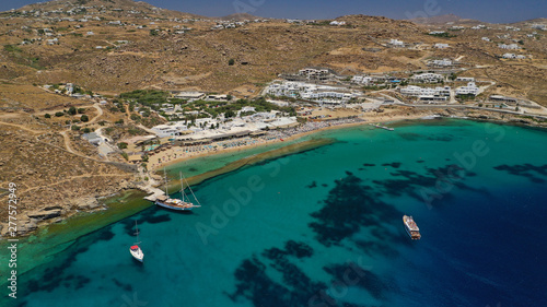 Aerial drone photo of famous organised with sun beds and umbrellas beach of Paradise with emerald clear sandy sea shore, Mykonos island, Cyclades, Greece 