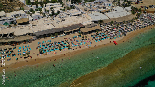 Aerial drone photo of famous organised with sun beds and umbrellas beach of  Paradise with emerald clear sandy sea shore, Mykonos island, Cyclades, Greece   © aerial-drone