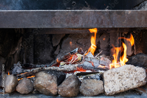 Close-up of the ashes and flames of a barbecue.