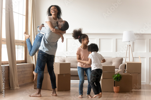 Happy excited african family celebrate moving day relocation together