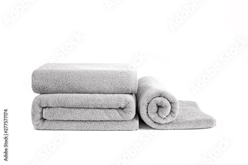 Fotografía Three gray terry towels rolled, folded and stacked isolated