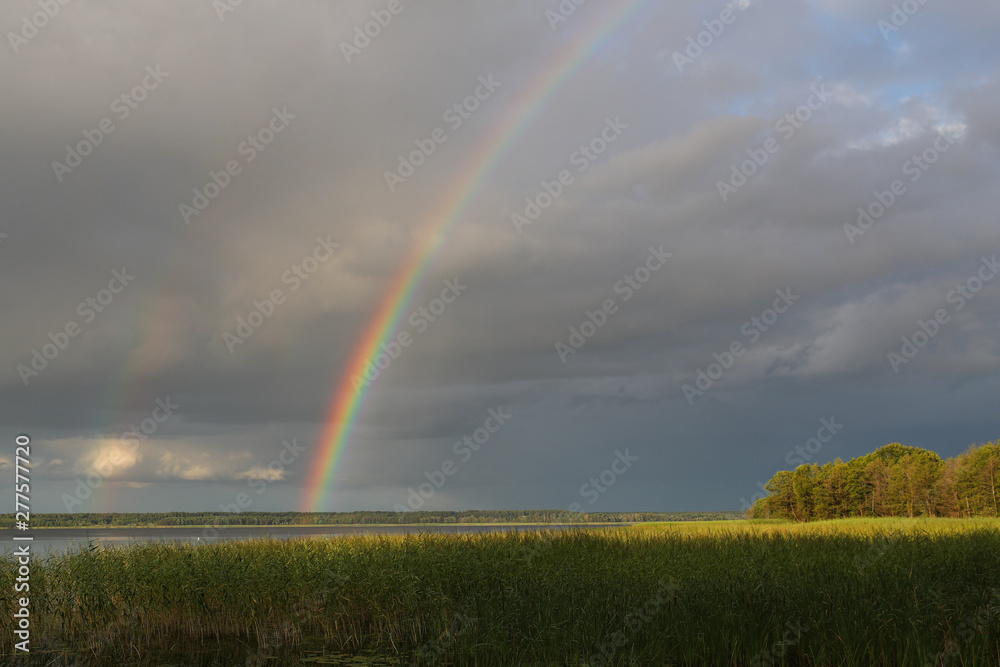 Rainbow over the lake in cloudy weather