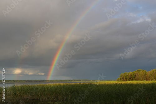 Rainbow over the lake in cloudy weather © makedonski2015