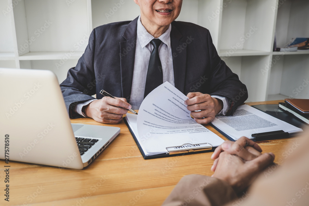 Interviewer or Board reading a resume during a job interview, Employer interviewing a young female job seeker for recruitment talking in modern office, employment and recruitment concept Interviewer or Board reading a resume during a job interview, Employer interviewing a young female job seeker for recruitment talking in modern office, employment and recruitment concept