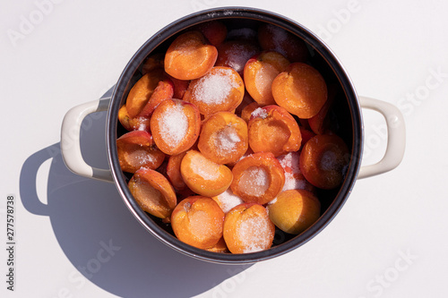 Half opened apricot covered with sugar, in a pan for cooking jam