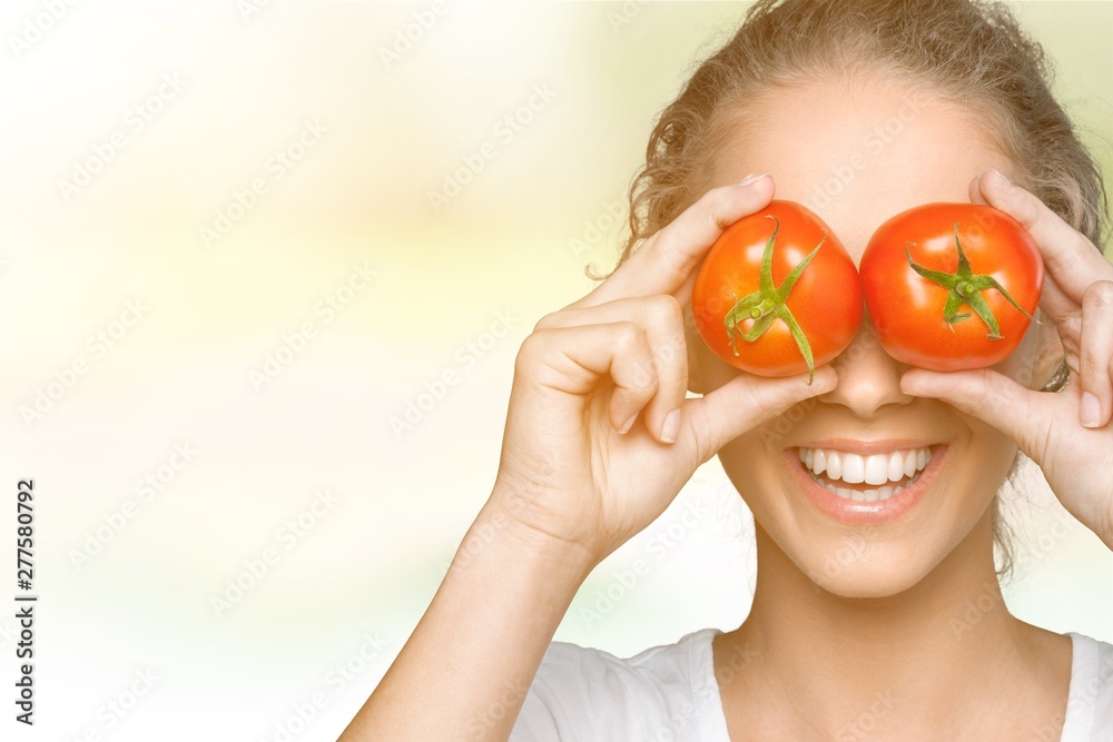 Beautiful laughing woman holding two ripe tomatoes Beautiful laughing woman holding two ripe tomatoes