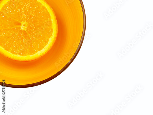  orange deep plate with half an orange on a white background located in the upper left corner flat lay