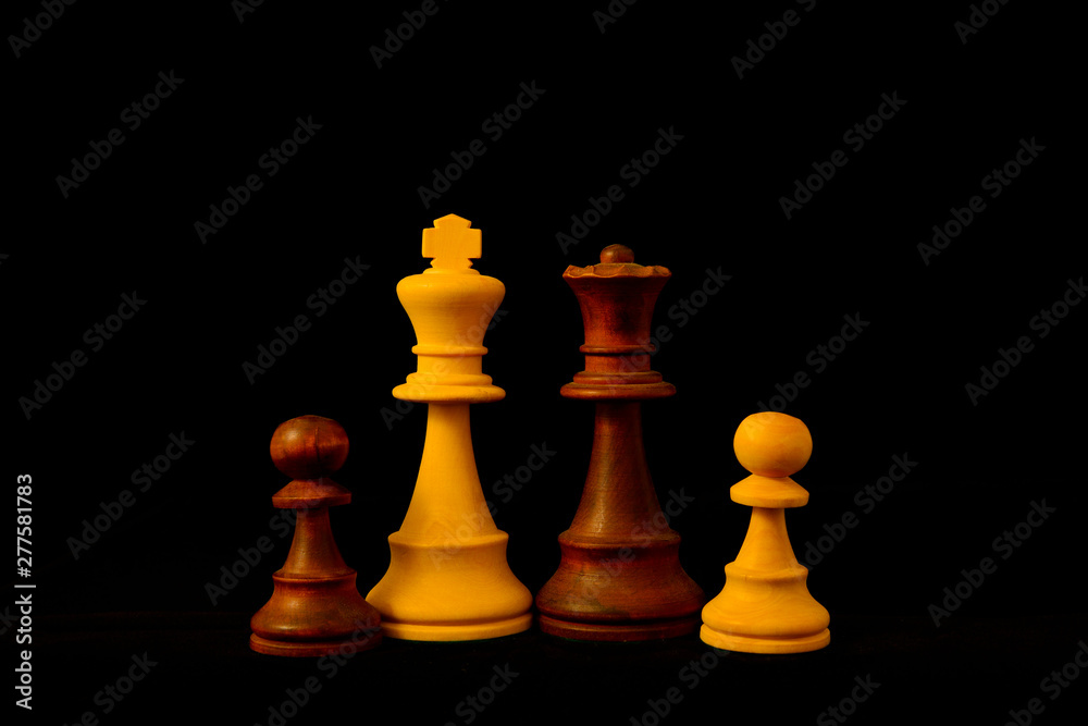 White King, Black Queen and Pawn as mixed family concept.Standard chess wooden pieces on black background
