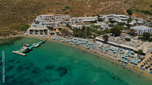 Aerial panoramic photo of famous turquoise clear sea celebrity sandy beach and bay of Psarou with yachts and sail boats in iconic island of Mykonos, Cyclades, Greece